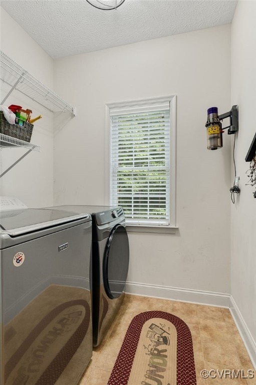 12300 Wynnstay Ln, Chesterfield, VA 23838 - laundry area featuring washing machine and clothes dryer, light tile patterned floors, baseboards, and a textured ceiling