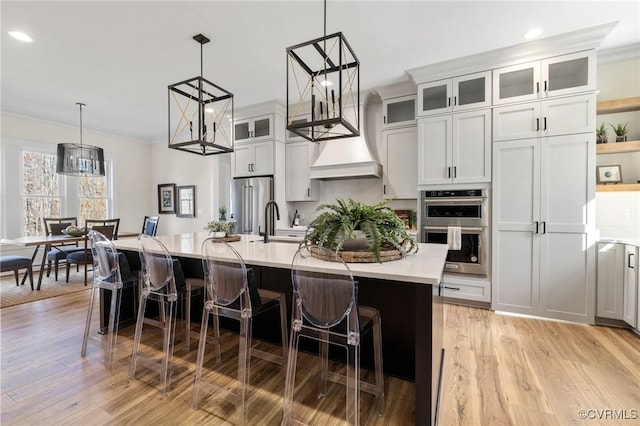 1570 Huntington Woods Trl, Powhatan, VA 23139 - kitchen with light countertops, stainless steel appliances, ornamental molding, a breakfast bar area, and an island with sink