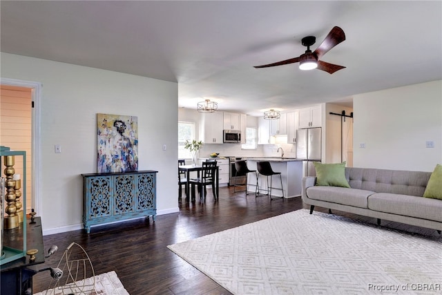 704 Athens Ave, Hampton, VA 23669 - living room featuring dark wood finished floors, a barn door, a ceiling fan, and baseboards