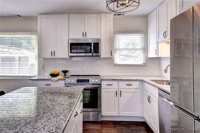704 Athens Ave, Hampton, VA 23669 - kitchen with appliances with stainless steel finishes, a sink, white cabinets, dark wood-type flooring, and decorative backsplash