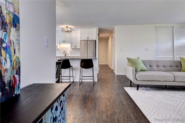 704 Athens Ave, Hampton, VA 23669 - living room featuring dark wood-style floors, baseboards, and a chandelier