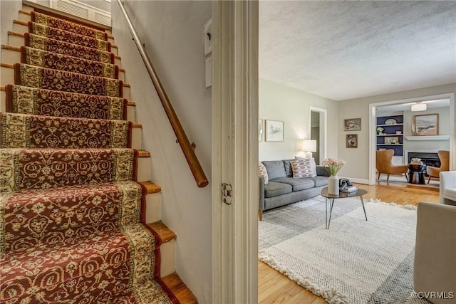 7400 Westfield Rd, Henrico, VA 23226 - staircase with wood finished floors, built in shelves, a textured ceiling, and baseboards