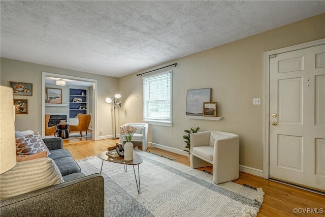 7400 Westfield Rd, Henrico, VA 23226 - living area featuring wood finished floors, a textured ceiling, baseboards, and built in shelves