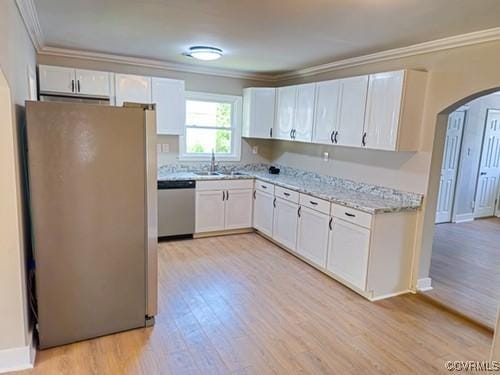 1217 Arlington St, Petersburg, VA 23803 - kitchen with stainless steel appliances, arched walkways, crown molding, light wood finished floors, and white cabinetry