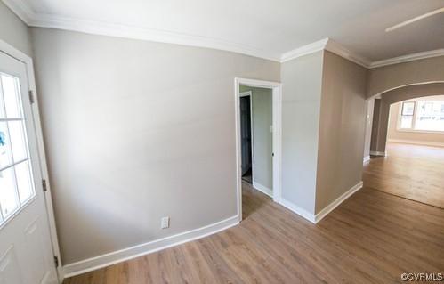 1217 Arlington St, Petersburg, VA 23803 - unfurnished room with arched walkways, wood finished floors, and ornamental molding