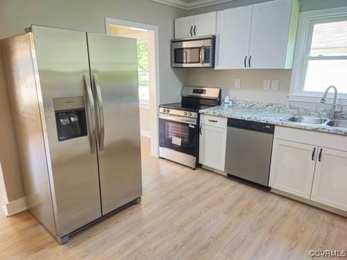 1217 Arlington St, Petersburg, VA 23803 - kitchen with appliances with stainless steel finishes, light wood-type flooring, crown molding, white cabinets, and light stone counters