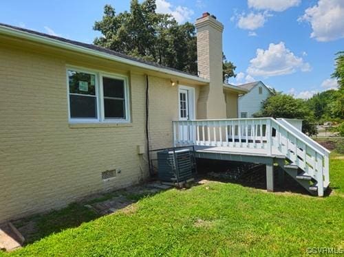 1217 Arlington St, Petersburg, VA 23803 - back of property with a lawn, a deck, a chimney, and brick siding