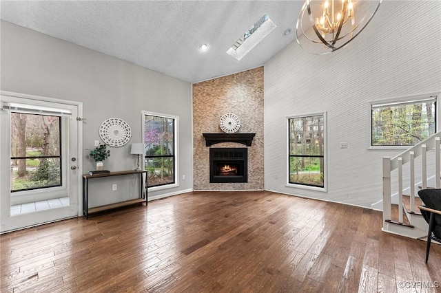 14323 Spring Gate Ct, Chesterfield, VA 23112 - unfurnished living room featuring a high ceiling, a chandelier, a large fireplace, stairway, and hardwood / wood-style flooring