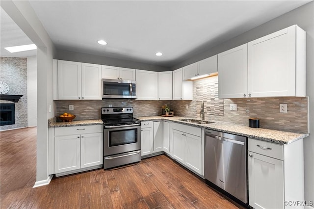 14323 Spring Gate Ct, Chesterfield, VA 23112 - kitchen featuring stainless steel appliances, a sink, dark wood finished floors, white cabinetry, and light stone countertops