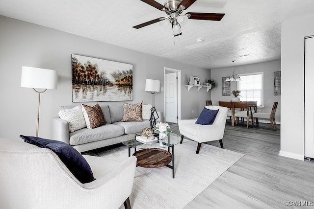 14560 Lodore Rd, Amelia Courthouse, VA 23002 - living area with a ceiling fan, light wood-style floors, baseboards, a textured ceiling, and a chandelier