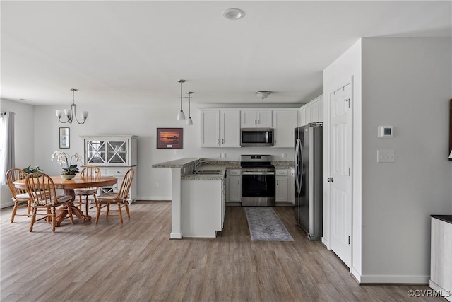319 Wendenburg Ter, King William, VA 23009 - kitchen featuring appliances with stainless steel finishes, a peninsula, baseboards, and wood finished floors