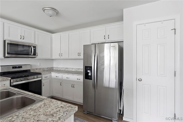 319 Wendenburg Ter, King William, VA 23009 - kitchen with stainless steel appliances, light countertops, wood finished floors, white cabinets, and a sink