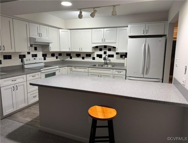 12003 Warrington Ct Unit 12003, Henrico, VA 23233 - kitchen featuring white appliances, a sink, under cabinet range hood, a kitchen bar, and tasteful backsplash