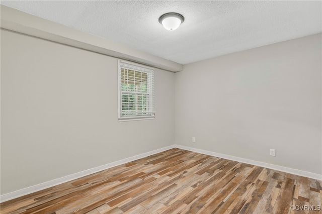 3411 Sylvania Rd, Chester, VA 23831 - unfurnished room with light wood finished floors, baseboards, and a textured ceiling