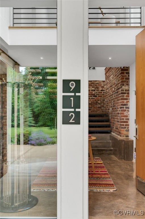 912 S Gaskins Rd, Henrico, VA 23238 - entryway featuring brick wall, finished concrete floors, and a high ceiling