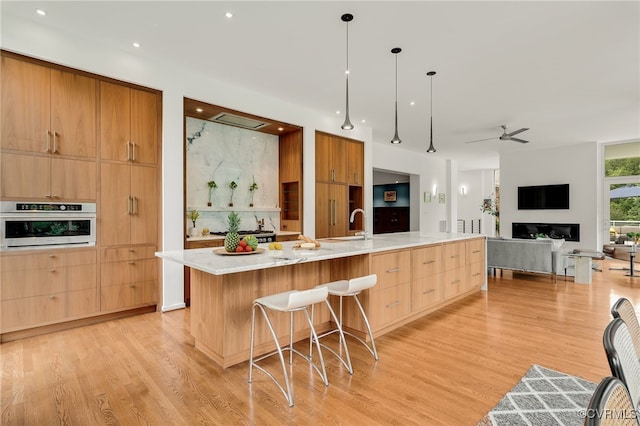 912 S Gaskins Rd, Henrico, VA 23238 - kitchen with modern cabinets, light wood finished floors, light countertops, a large island with sink, and a ceiling fan
