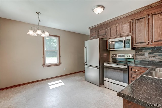 4509 Lockin Rd, Powhatan, VA 23139 - kitchen with stainless steel appliances, dark countertops, backsplash, a chandelier, and decorative light fixtures