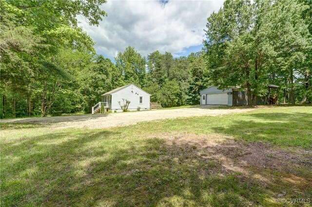 4509 Lockin Rd, Powhatan, VA 23139 - view of grassy yard with a garage, an outdoor structure, and a forest view