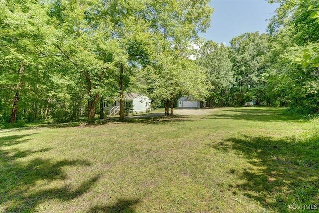 4509 Lockin Rd, Powhatan, VA 23139 - view of green lawn featuring a garage, an outbuilding, and a forest view