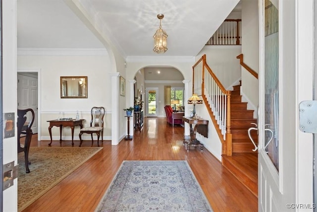 403 Regina Ln, Richmond, VA 23238 - entrance foyer featuring arched walkways, crown molding, wood finished floors, stairs, and decorative columns
