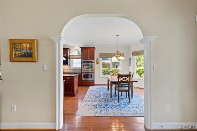 403 Regina Ln, Richmond, VA 23238 - dining space with arched walkways, ornate columns, hardwood / wood-style flooring, and baseboards