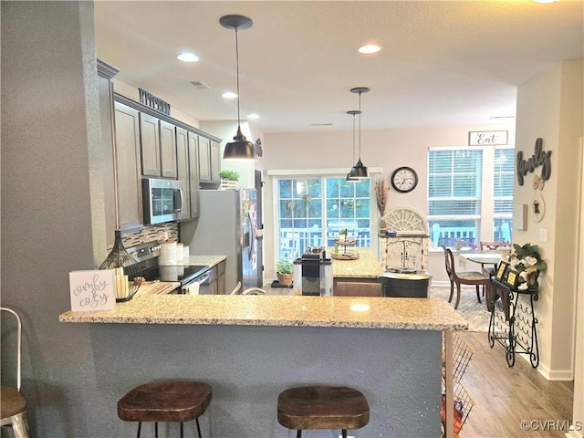 705 Prosperity Ct Unit 705, Williamsburg, VA 23188 - kitchen featuring appliances with stainless steel finishes, a kitchen bar, light wood-style flooring, a peninsula, and recessed lighting