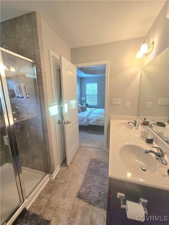 705 Prosperity Ct Unit 705, Williamsburg, VA 23188 - bathroom with double vanity, ensuite bathroom, a shower stall, and a textured ceiling