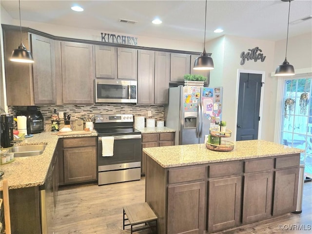 705 Prosperity Ct Unit 705, Williamsburg, VA 23188 - kitchen with appliances with stainless steel finishes, decorative backsplash, light wood finished floors, a kitchen island, and recessed lighting