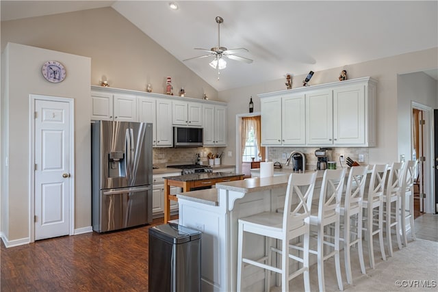 16180 Janet Dr, Amelia Courthouse, VA 23002 - kitchen with stainless steel appliances, ceiling fan, a peninsula, a kitchen breakfast bar, and white cabinets