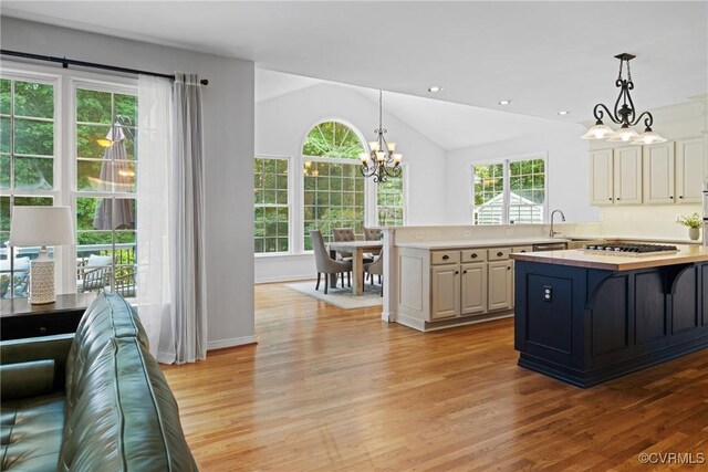11137 Sterling Cove Dr, Chesterfield, VA 23838 - kitchen featuring a chandelier, light wood-style flooring, decorative light fixtures, lofted ceiling, and stainless steel gas stovetop