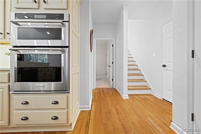 11137 Sterling Cove Dr, Chesterfield, VA 23838 - kitchen with stainless steel double oven, cream cabinetry, light wood-type flooring, light countertops, and baseboards