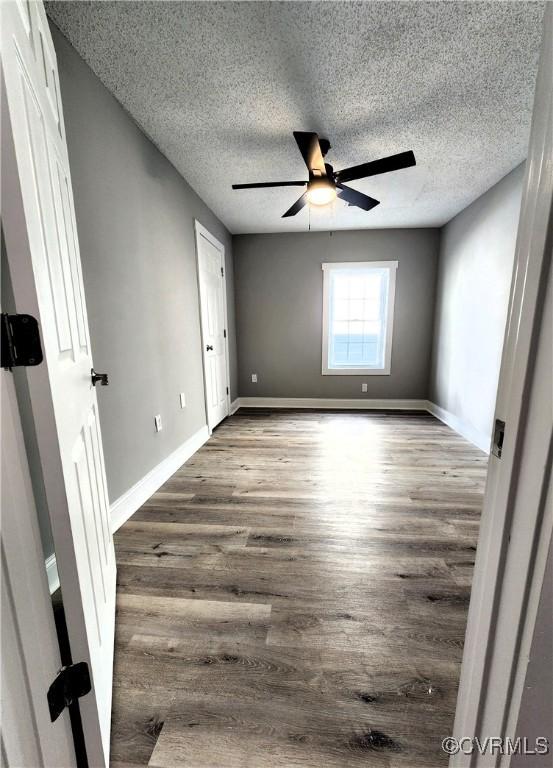 1118 27th, Richmond, VA 23223 - unfurnished bedroom with a textured ceiling, wood finished floors, baseboards, and a ceiling fan