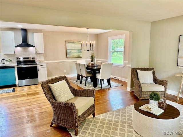 8409 Zell Ln, Henrico, VA 23229 - living room featuring a chandelier, light wood-type flooring, and baseboards