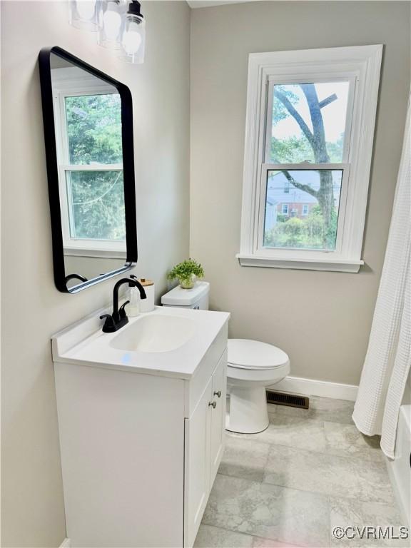 8409 Zell Ln, Henrico, VA 23229 - bathroom with vanity, toilet, baseboards, and shower / bath combo