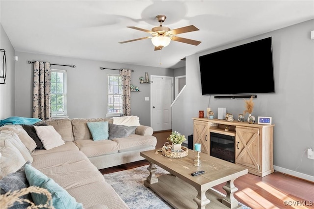 7012 Autumn Point Dr, North Chesterfield, VA 23234 - living room with light wood-style flooring, ceiling fan, a glass covered fireplace, and baseboards
