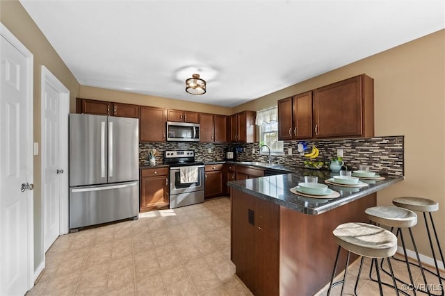 7012 Autumn Point Dr, North Chesterfield, VA 23234 - kitchen with appliances with stainless steel finishes, a peninsula, decorative backsplash, a kitchen bar, and a sink