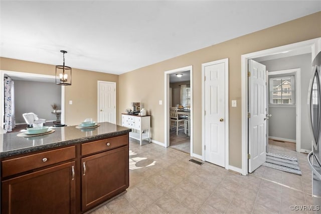 7012 Autumn Point Dr, North Chesterfield, VA 23234 - kitchen with decorative light fixtures, dark stone counters, and baseboards