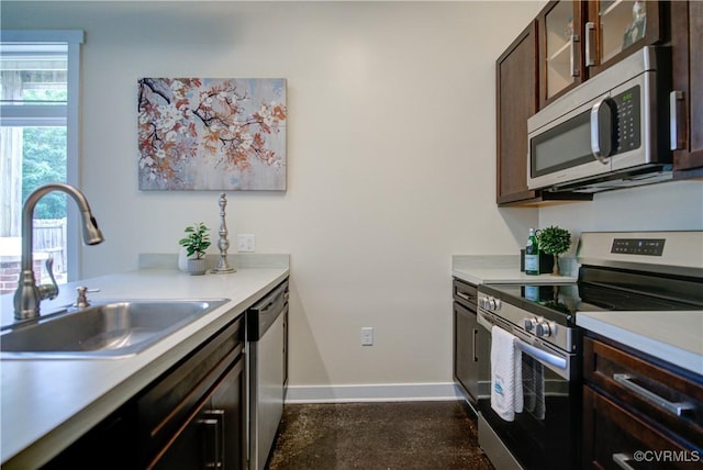 1020 Porter St Unit 103, Richmond, VA 23224 - kitchen with stainless steel appliances, a sink, baseboards, light countertops, and dark brown cabinetry