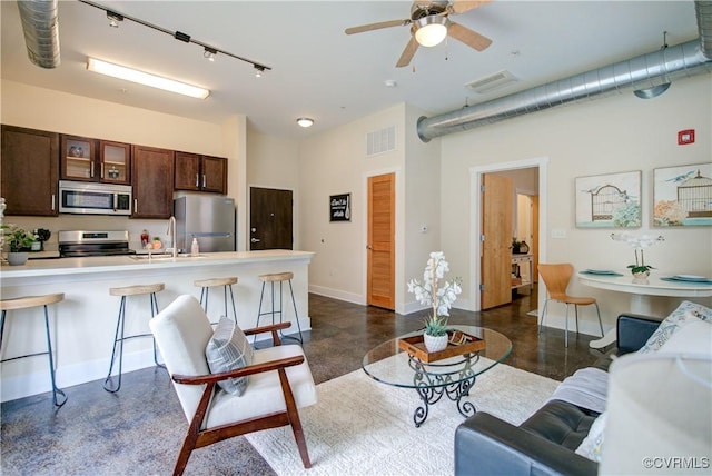 1020 Porter St Unit 103, Richmond, VA 23224 - living area featuring finished concrete floors, track lighting, baseboards, high vaulted ceiling, and ceiling fan
