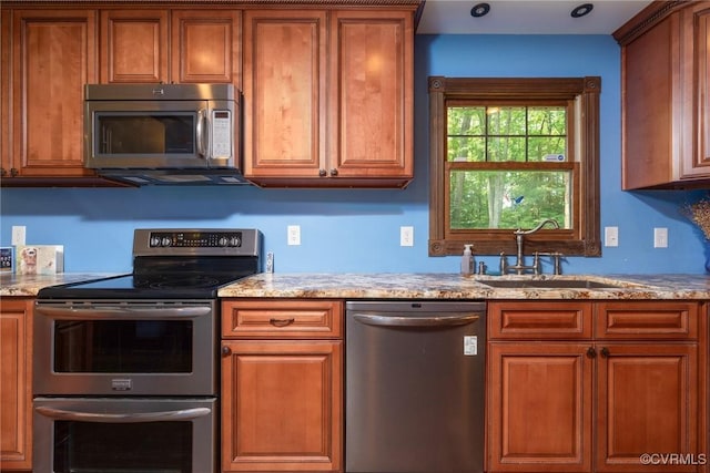 14421 Clazemont Rd, Montpelier, VA 23192 - kitchen featuring stainless steel appliances, brown cabinetry, and light stone countertops