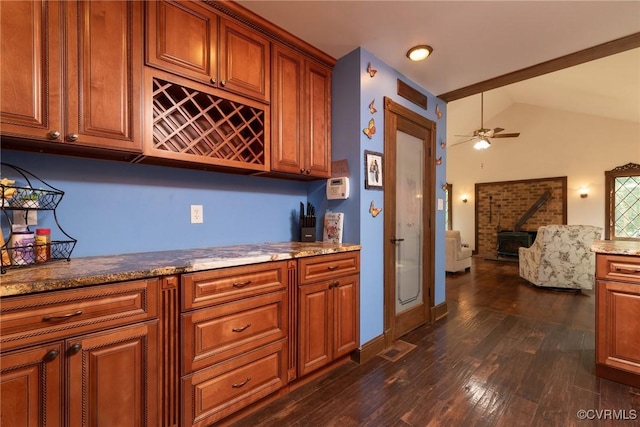 14421 Clazemont Rd, Montpelier, VA 23192 - kitchen with a wood stove, dark wood-type flooring, brown cabinetry, vaulted ceiling, and open floor plan