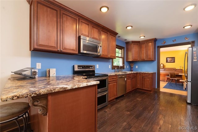 14421 Clazemont Rd, Montpelier, VA 23192 - kitchen featuring stainless steel appliances, dark wood-style flooring, brown cabinets, recessed lighting, and a kitchen bar