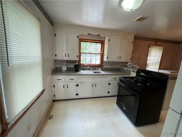737 Jefferson Pl, Petersburg, VA 23803 - kitchen featuring black range with gas stovetop, a sink, white cabinetry, a peninsula, and light flooring