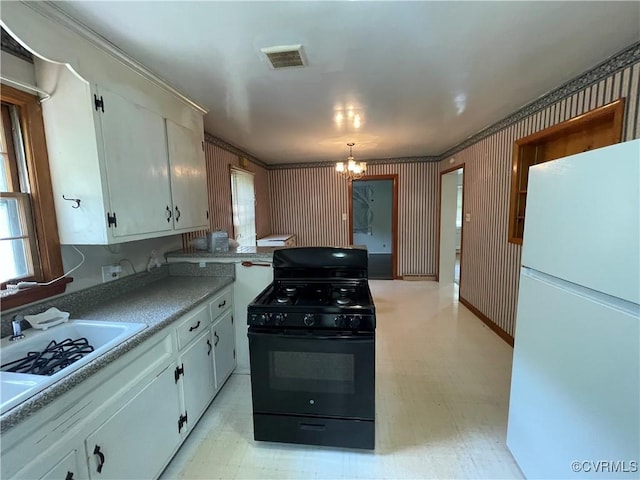 737 Jefferson Pl, Petersburg, VA 23803 - kitchen with gas stove, freestanding refrigerator, a chandelier, light flooring, and white cabinets