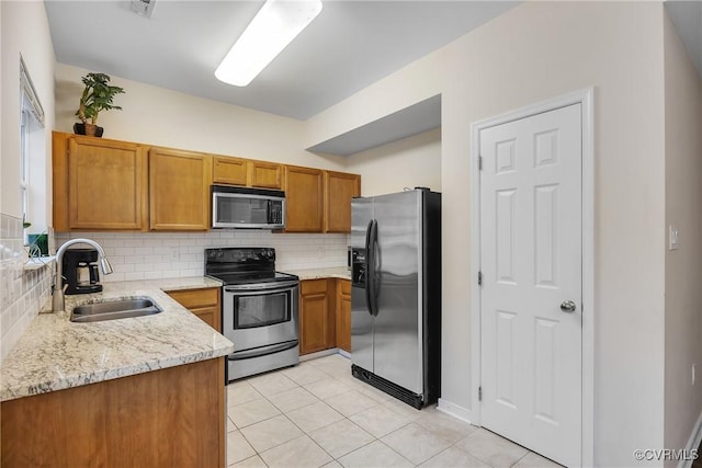 4613 Milfax Rd, Chesterfield, VA 23224 - kitchen with stainless steel appliances, tasteful backsplash, brown cabinets, light stone countertops, and light tile patterned floors