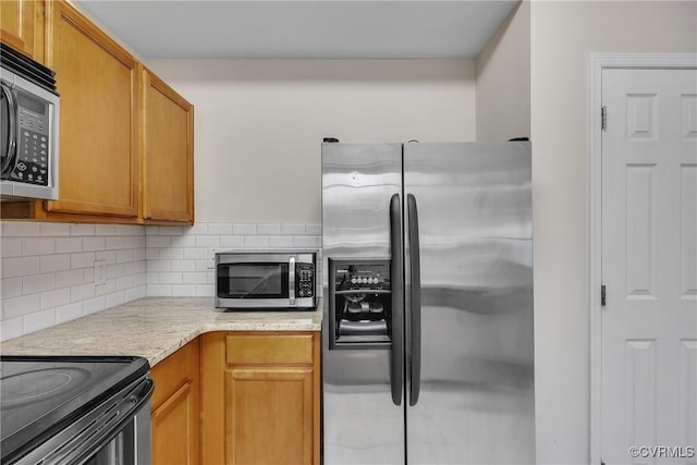 4613 Milfax Rd, Chesterfield, VA 23224 - kitchen with appliances with stainless steel finishes, tasteful backsplash, and brown cabinets