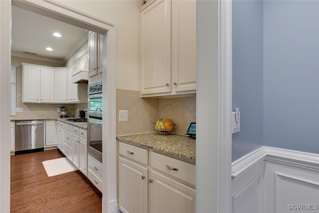 11715 Triple Notch Ter, Henrico, VA 23233 - kitchen with appliances with stainless steel finishes, ornamental molding, dark wood-type flooring, white cabinets, and light stone counters