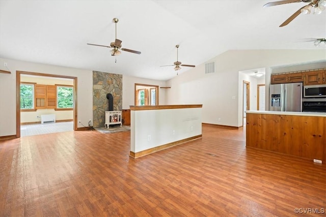 3786 Donavon Mill Ct, Powhatan, VA 23139 - unfurnished living room featuring ceiling fan, light wood-style floors, a wood stove, lofted ceiling, and baseboards