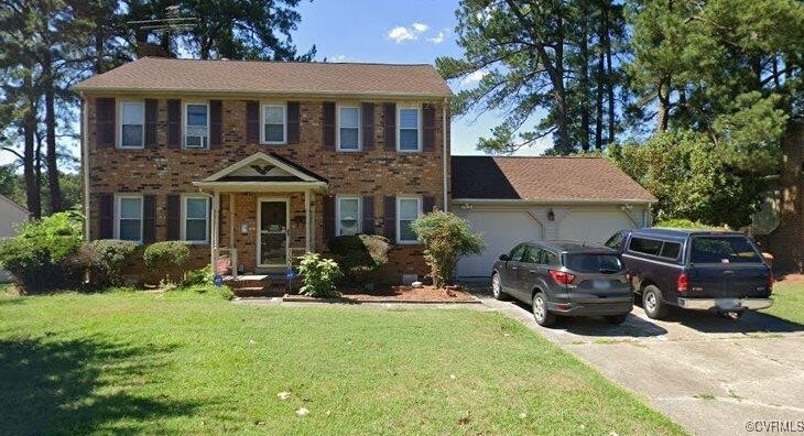 237 Greenwood Dr, Petersburg, VA 23805 - colonial house with driveway, an attached garage, a front yard, and brick siding