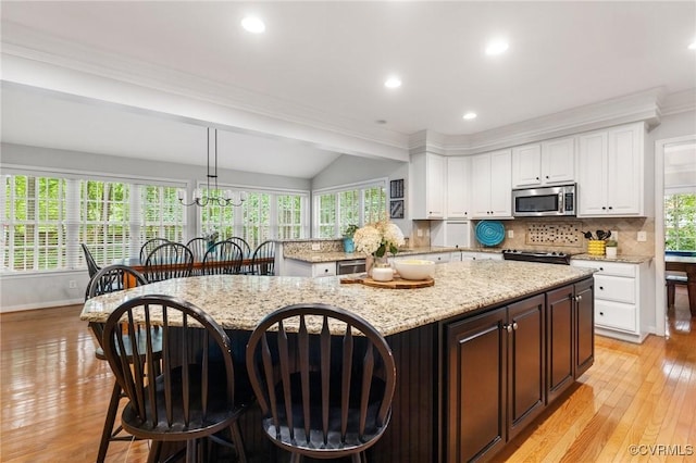 11601 Shadow Run Ln, Glen Allen, VA 23059 - kitchen with appliances with stainless steel finishes, white cabinetry, light wood-style floors, decorative backsplash, and vaulted ceiling